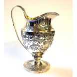 A GEORGIAN SILVER CLASSICAL HELMET FORM CREAM JUG With embossed decoration and gilt interior,