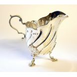 A VICTORIAN SILVER CREAM JUG Having a fluted body with tripod legs, hallmarked London, 1891. (approx