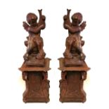 A PAIR 19TH CENTURY OF CAST IRON CHERUBS Standing on scroll worked plinths. (83cm x 43cm including