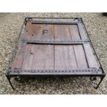A LARGE 18TH/19TH CENTURY HARDWOOD DOOR With lightly carved decoration and heavy iron strap work,