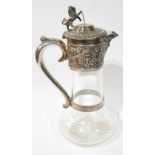 A VICTORIAN SILVER AND GLASS CLARET JUG Having a lion finial and embossed decoration of vine