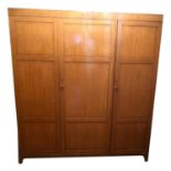 AN EARLY 20TH CENTURY SATINWOOD TRIPLE WARDROBE With panelled doors enclosing a partially fitted