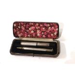 A CASED EARLY 20TH CENTURY SILVER FOUNTAIN PEN AND PENCIL SET Having engine turned decoration,