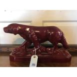 AN ART DECO LEMOINE RED GLAZED STATUE OF A HUNTING DOG. (41cm x 23cm)