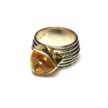 A VINTAGE 14CT GOLD AND CITRINE BAND RING The single trillion cut stone set on a wide band shank (