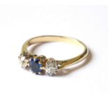 AN EARLY 20TH CENTURY DIAMOND AND SAPPHIRE THREE STONE RING The oval cut sapphire flanked by two