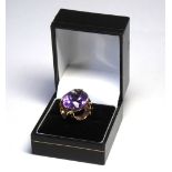 A VINTAGE 9CT GOLD AMETHYST COCKTAIL RING The oval cut stone in a pierced mount (size L). (weight