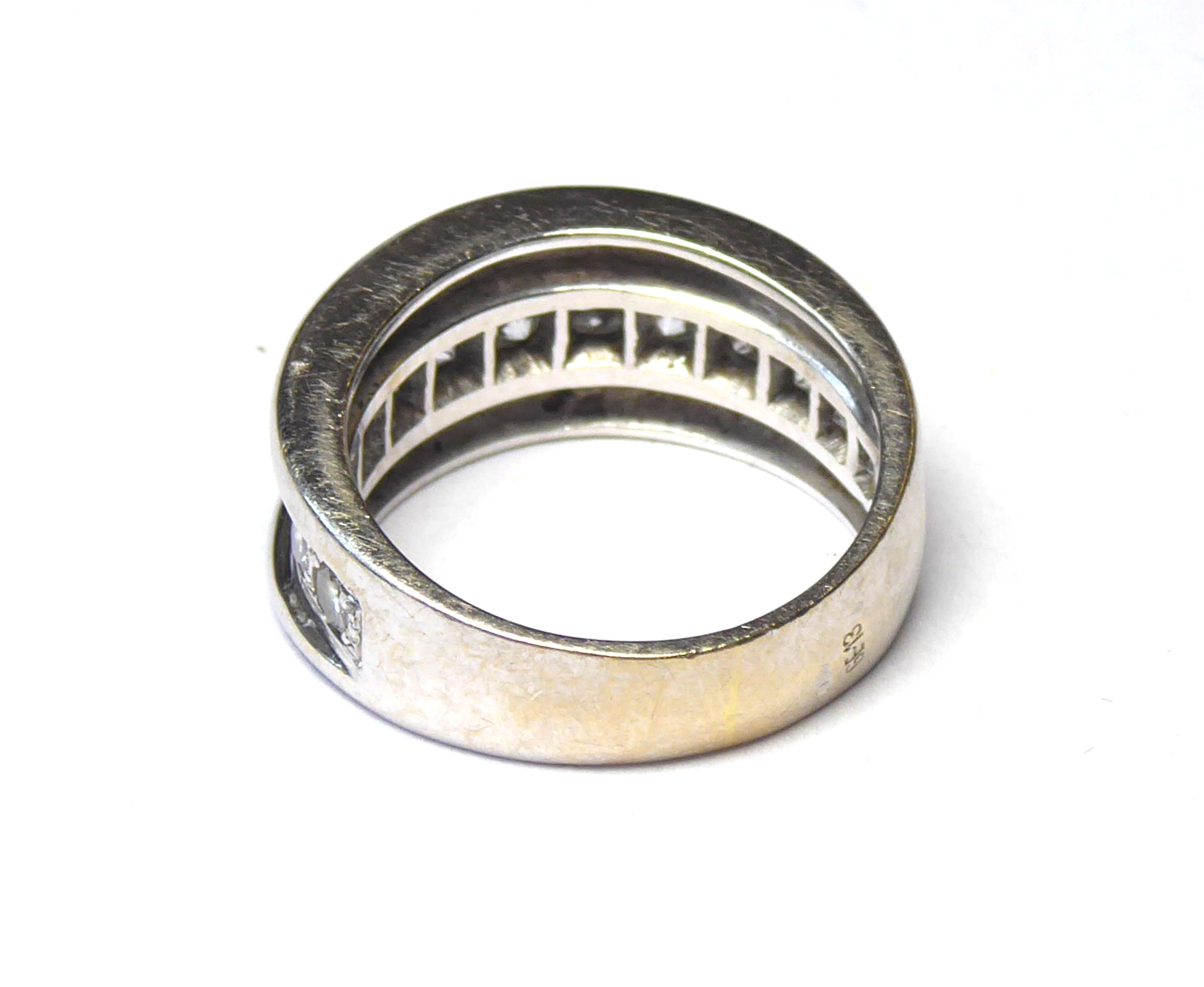 A WHITE METAL AND DIAMOND BAND RING The arrangement of graduating stones in a run over setting (size - Image 2 of 2