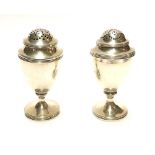 A PAIR OF GEORGIAN SILVER BALUSTER PEPPERETTES With pierced dome and reeded border, hallmarked James