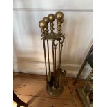 A SET OF FOUR BRASS FIRE TOOLS ON STAND.