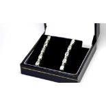 A PAIR OF 18CT ART DECO DESIGN WHITE GOLD EARRINGS SET WITH 1.6CT OF EMERALD CUT DIAMONDS. (drop