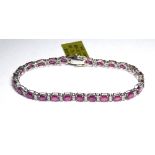 AN 18K WHITE GOLD BRACELET, Set with 13.14 rubies and 0.65 diamonds. (18cm) weight approx 9gm. All