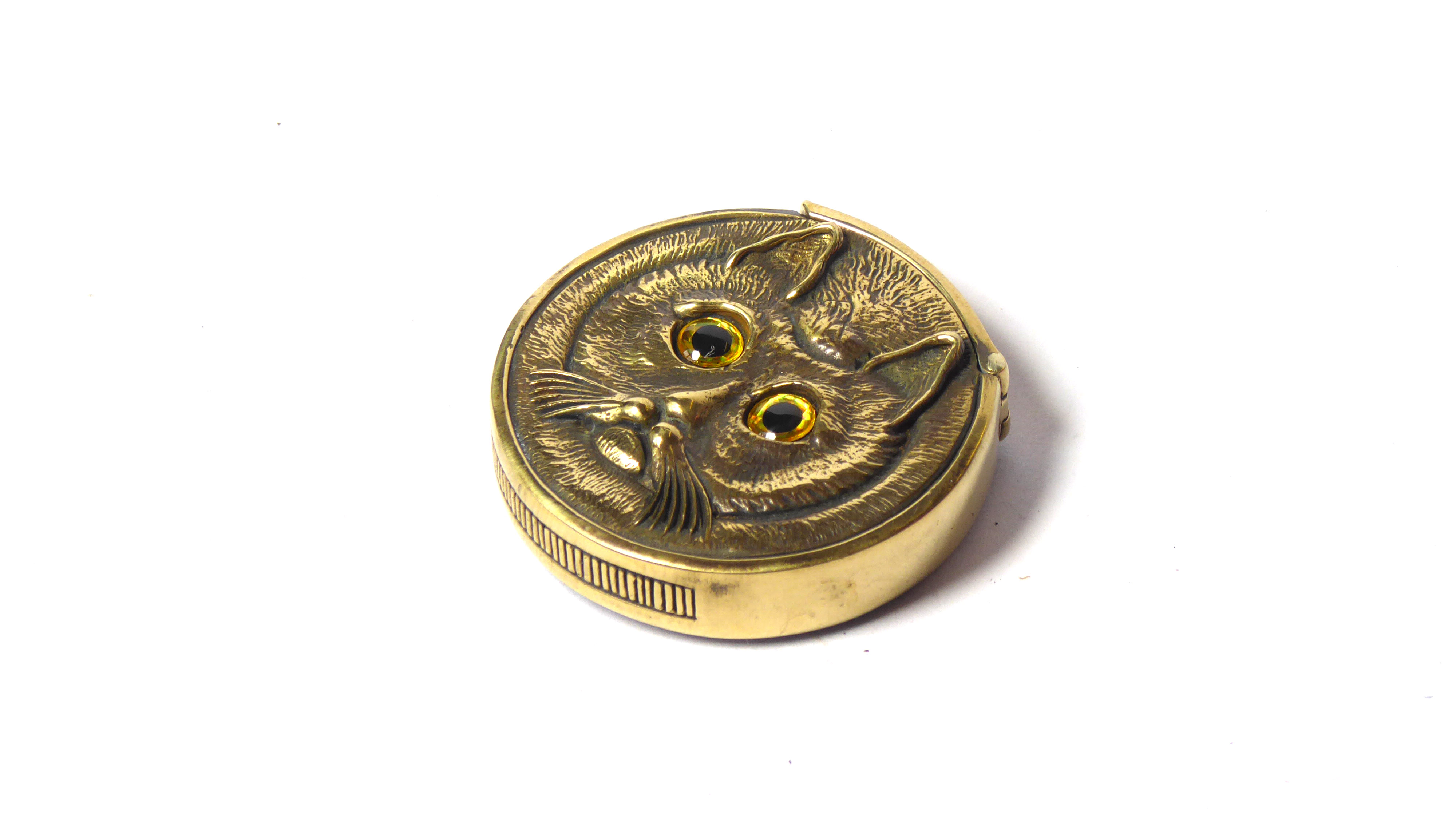 A BRASS NOVELTY VESTA CASE Twin sided, modelled as a cat's head with glass eyes. (approx 4cm) ( - Image 2 of 3