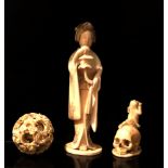 A JAPANESE MEJI PRIOD IVORY STATUE OF A GEISHA Along with a puzzle ball and a skull. (largest 16cm)