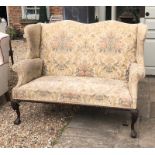 AN EARLY 20TH CENTURY GEORGIAN DESIGN WINGBACK SEATER SETTEE In a floral upholstered mahogany