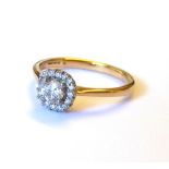 AN 18K GOLD AND DIAMOND HALO SET RING , round brilliant central stone 0.34ct (size L). weight approx