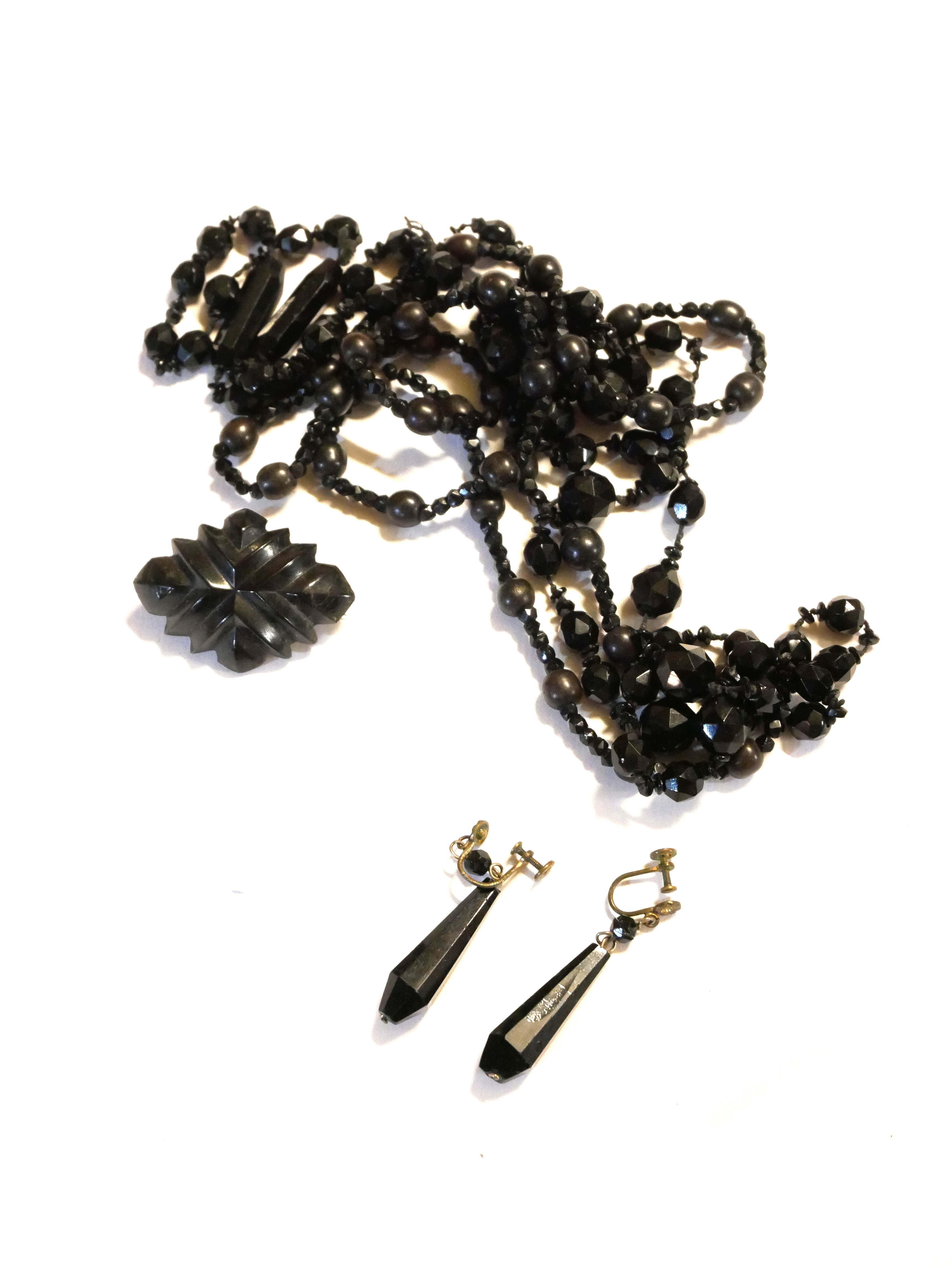 A COLLECTION OF VICTORIAN JET JEWELLERY Comprising a necklace, lozenge form brooch and a pair of