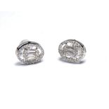 A PAIR OF 18K WHITE GOLD AND DIAMOND OVAL HALO SET EARRINGS Centred with baguette cuts. (1cm)
