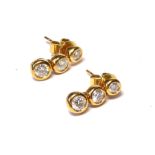 A PAIR OF 18CT GOLD AND DIAMOND DROP EARRINGS Each set with three round cut diamonds, stud backs. (