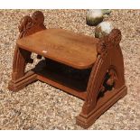 A VICTORIAN GOTHIC REVIVAL OAK STOOL The pointed arched supports heavily carved with a mythical