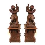 A PAIR 19TH CENTURY OF CAST IRON CHERUBS Standing on scroll worked plinths. (83cm x 43cm including