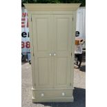 A PAINTED PINE WARDROBE Having a pair of panned doors over drawer, raised on a plinth base. (h 188cm