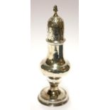 A GEORGIAN SILVER BALUSTER CASTER Having a pierced dome lid, with engraved armorial crest 'Dum