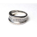 A WHITE METAL AND DIAMOND BAND RING The arrangement of graduating stones in a run over setting (size