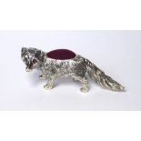 A SILVER AND RUBY NOVELTY PIN CUSHION Modelled as a fox with ruby eyes and velvet cushion, marked .