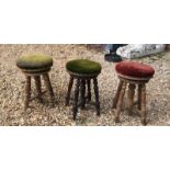 THREE EDWARDIAN ADJUSTABLE PIANO STOOLS With circular upholstered seats, raised on turned legs. (