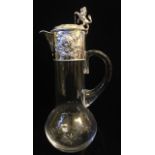 A VICTORIAN SILVER AND CUT GLASS CLARET JUG Rampant lion finial and embossed design of Bacchus