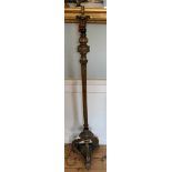 A 19TH CENTURY CARVED WOOD AND PAINTED FLOORSTANDING LAMP Decorated with leaves, raised on scrolling