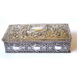 AN EARLY 20TH CENTURY WHITE METAL RECTANGULAR CIGARETTE BOX With embossed scrolled decoration and