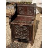 A VICTORIAN HEAVILY CARVED OAK SETTLE/PERDONIUM. (82cm x 53cm x 43cm)