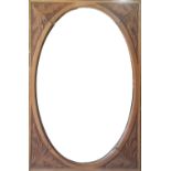 AN EDWARDIAN SATIN WALNUT AND CARVED MIRROR With oval bevelled plate. (70cm x 107cm)