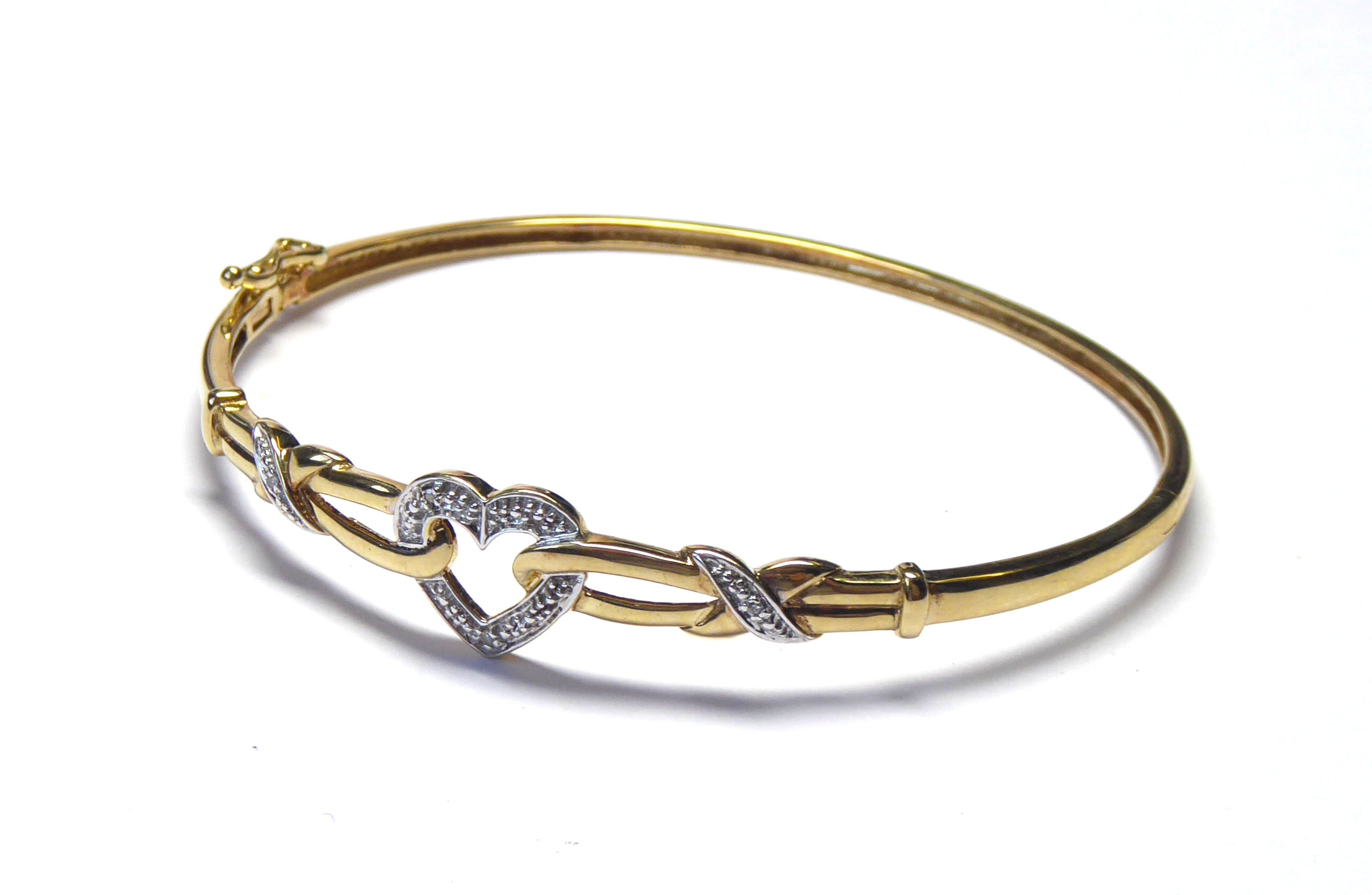 A 9CT GOLD AND DIAMOND BANGLE Heart form motif set with pavé diamonds on a rope twist mount. (approx