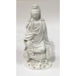 AN 18TH CENTURY CHINESE BLANC DE CHINE PORCELAIN FIGURE OF GUANYIN In seated pose on rustic base. (