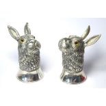 A PAIR OF CONTINENTAL SILVER NOVELTY SALT AND PEPPER POTS modelled as hares/rabbits with glass eyes,