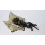 A COLD PAINTED BRONZE FIGURAL PAPERWEIGHT Modelled as a Dachshund on a pillow. (approx 9cm)