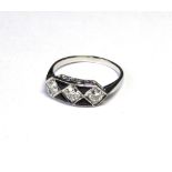 AN 18CT GOLD, DIAMOND AND BLACK ONYX RING Three round cut stones in a geometric Art Deco design