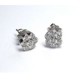 A PAIR OF 18K WHITE GOLD DAISY SET EARRINGS Set with 1.01ct diamonds.