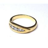 AN 18CT GOLD AND DIAMOMD FIVE STONE RING Graduating round cut stones in a rub over setting (size N).