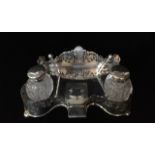 AN EARLY 20TH CENTURY SILVER PLATED INKSTAND Having two cut glass bottles on a pierced stand. (