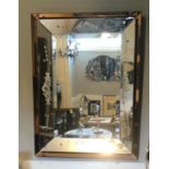 AN ART DECO SILVERED AND PEACH GLASS MIRROR With acid edged floral decorated borders surrounding a