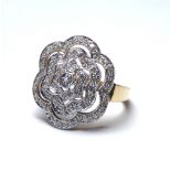 A 9CT GOLD AND PAVÉ SET DIAMOND CLUSTER RING Forming a pierced floral design on a yellow gold