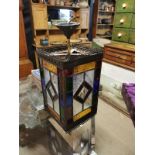 AN EDWARDIAN BRASS AND COLOURED LEAD GLASS RECTANGULAR LANTERN With geometric coloured glass panels.