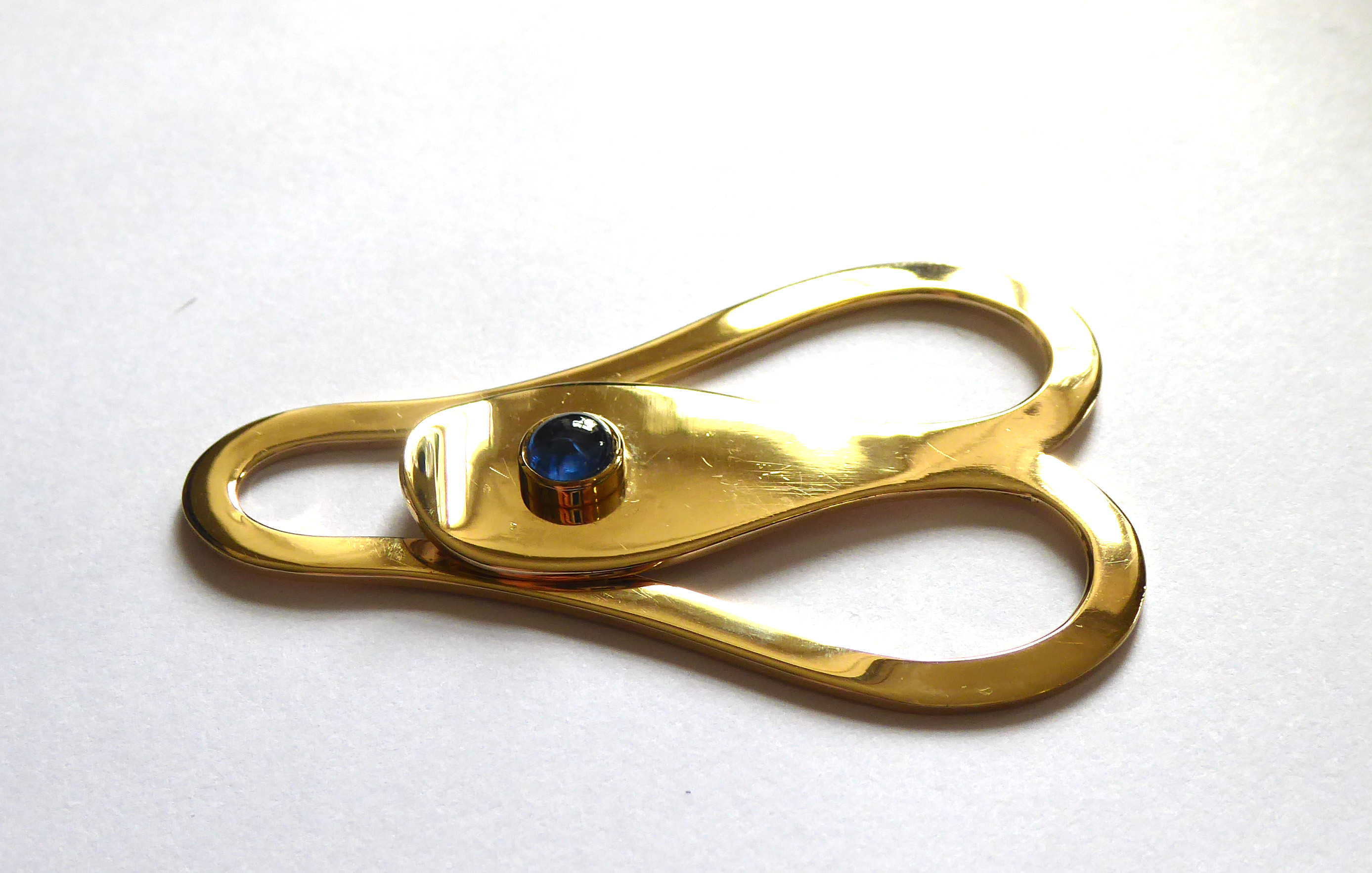 ASPREY, A VINTAGE 9CT GOLD AND SAPPHIRE MONEY CLIP Having a cabochon cut sapphire set in a plain