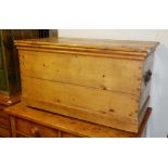 A 19TH CENTURY PINE CHEST With iron carrying handles, raised on casters. (93cm x 50cm x 48cm)
