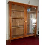 A STAINED PINE GLAZED WALL HANGING CABINET With fitted shelves. (95cm x 26cm x 111cm)