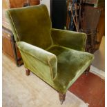 A LATE VICTORIAN EASY ARMCHAIR in green velvet upholstery, raised on turned legs with casters. (75cm